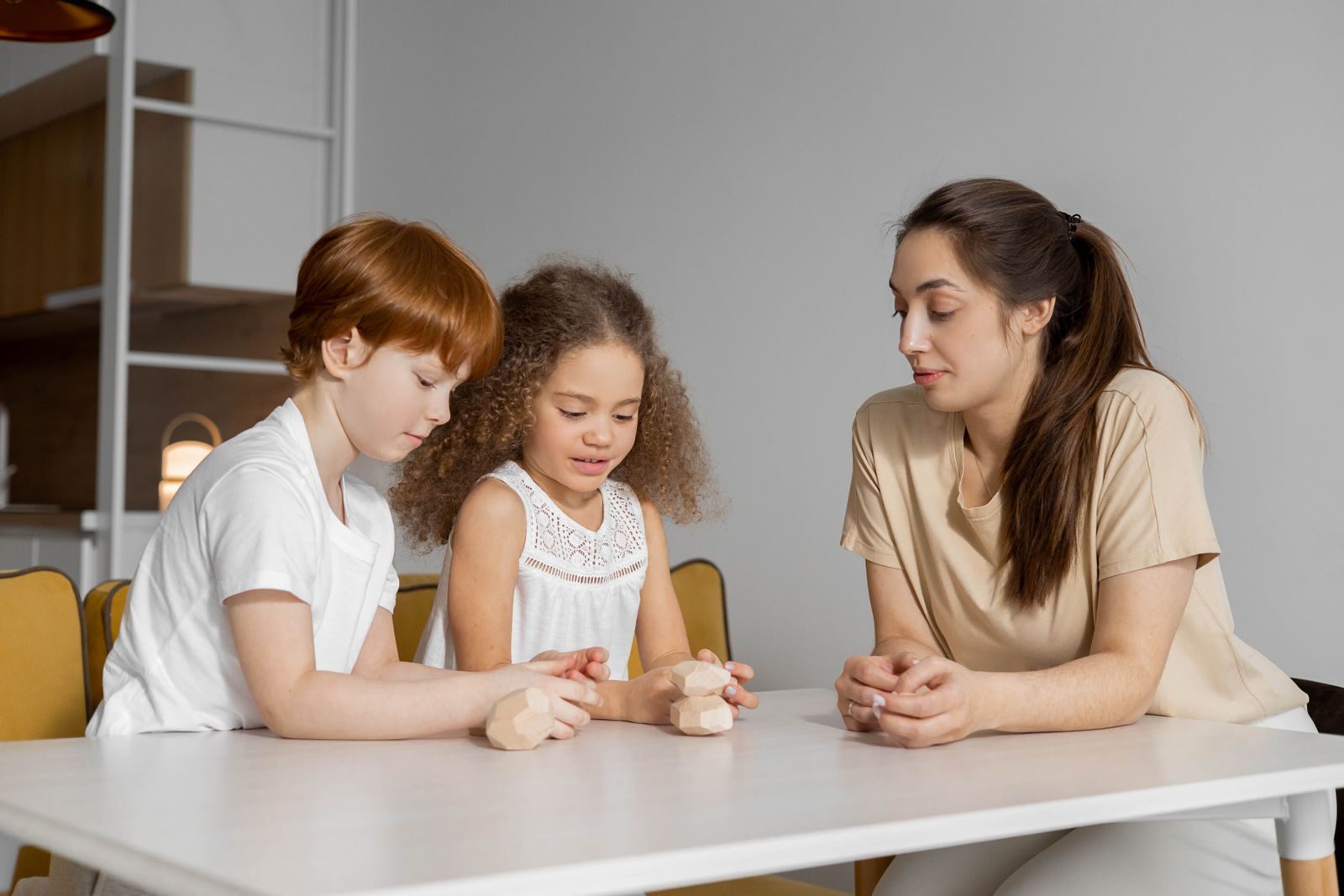 مربية تلعب مع الأطفال داخل المنزل - صورة توضيحية